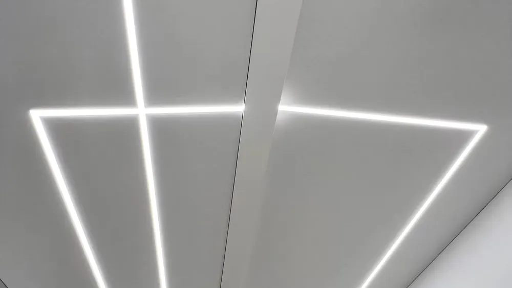 Baltos lubos su geometrinėmis įleistomis šviesos linijomis